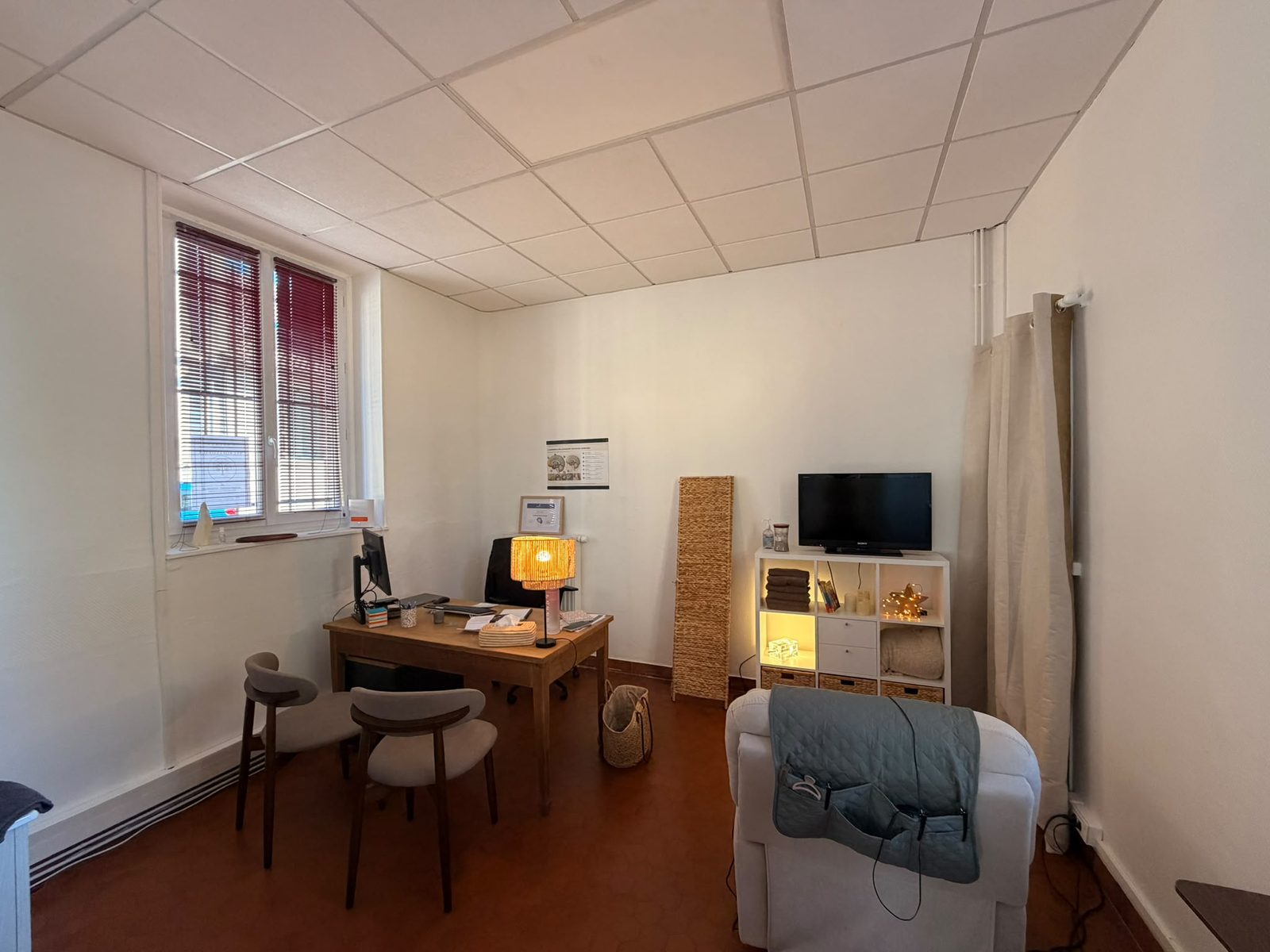 Intérieur du cabinet de neurofeedback à Noisy-le-Roi : bureau, fauteuil confortable et lumière douce
